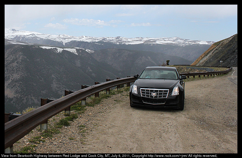 Snow capped mountains above a green valley.